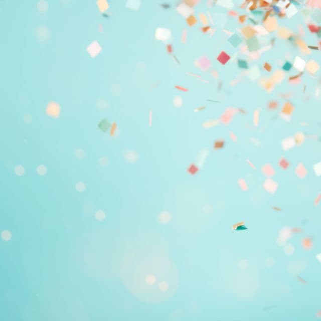 Confetti falling against a pale sky