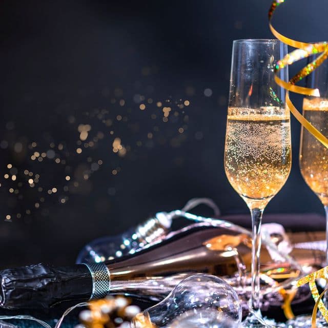Gold champagne flutes with streamers at midnight