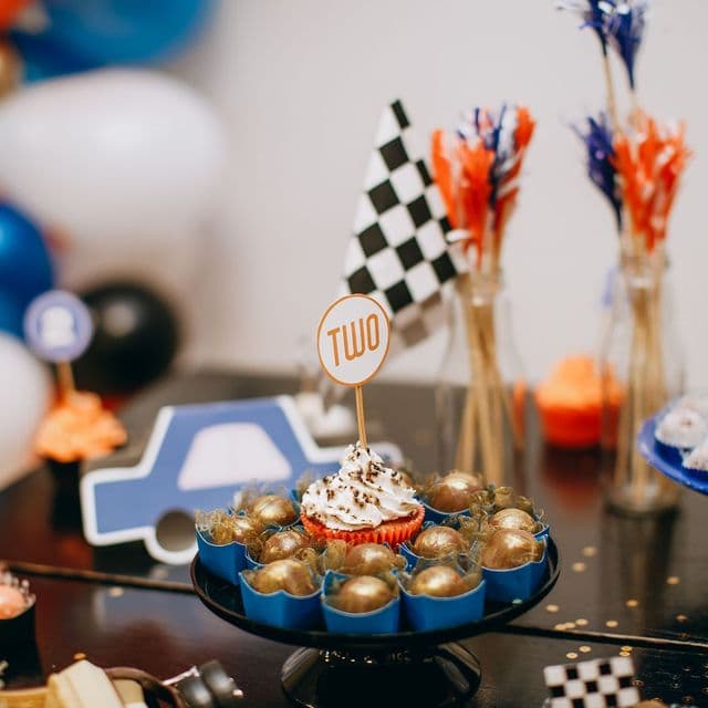 A race-themed birthday dessert table with a checkered flag