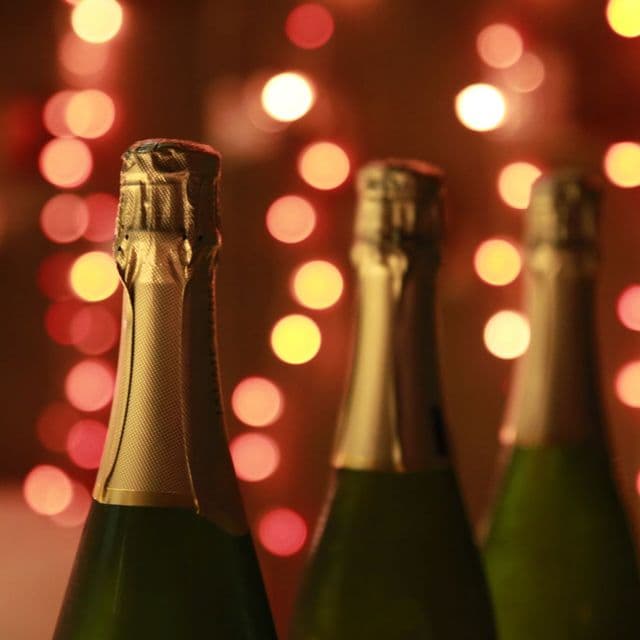Champagne bottles against golden party bokeh