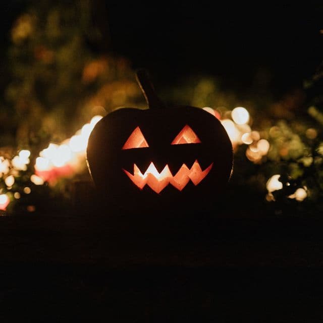 A carved jack-o-lantern glowing in the dark