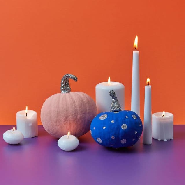 Painted pumpkins and candles in a modern Halloween still life