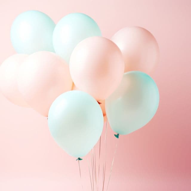 A cluster of pastel pink and mint balloons