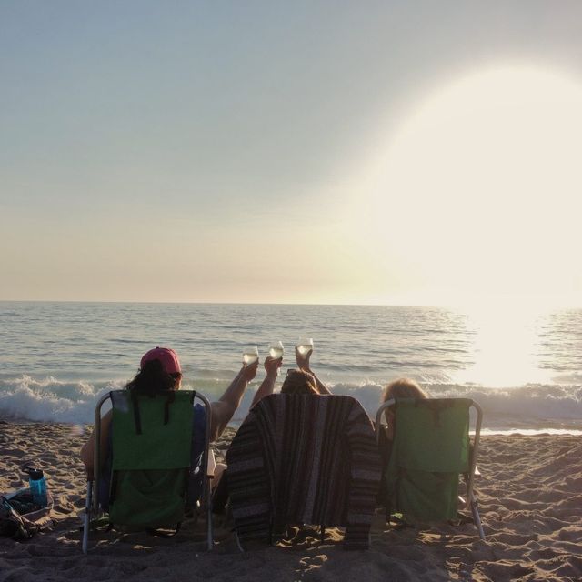 Friends sitting together at sunset, seen from behind