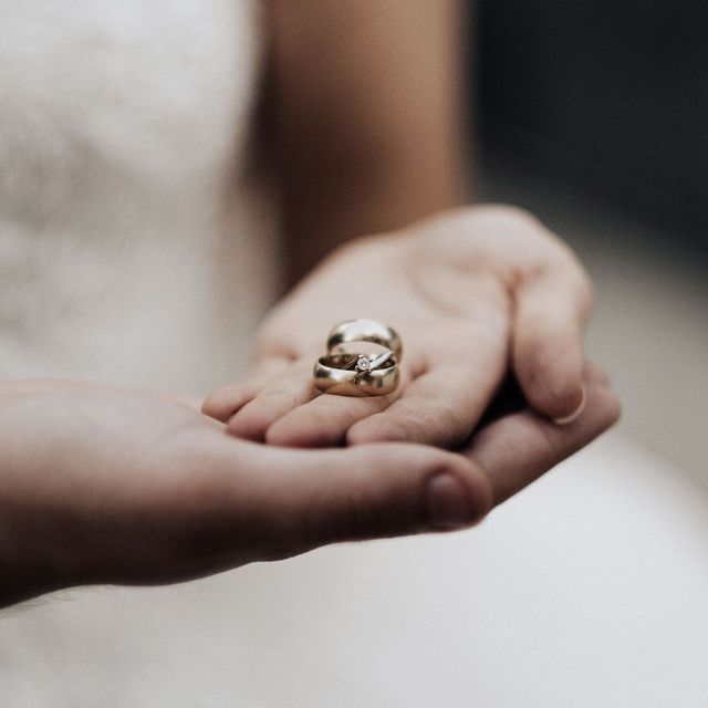 An engagement ring held in an open palm