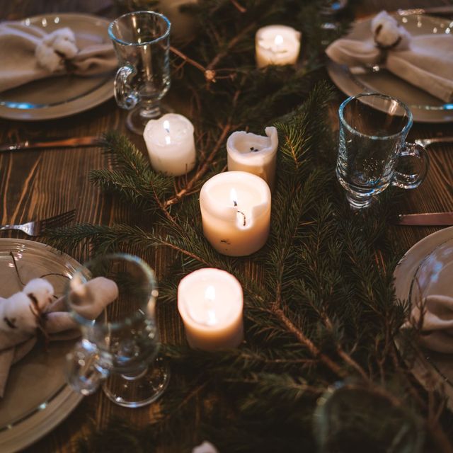 Candles glowing on a decorated holiday table